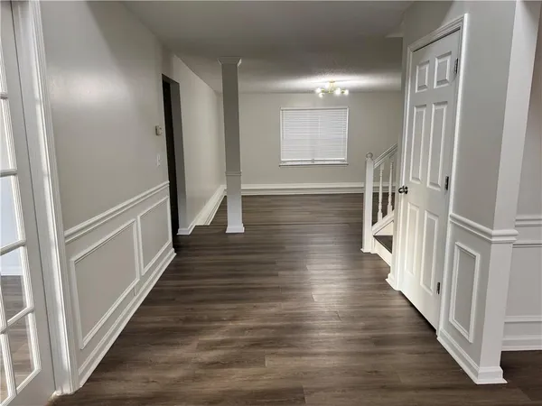 a view of a hallway with wooden floor and staircase