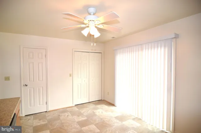 an empty room with fan and windows
