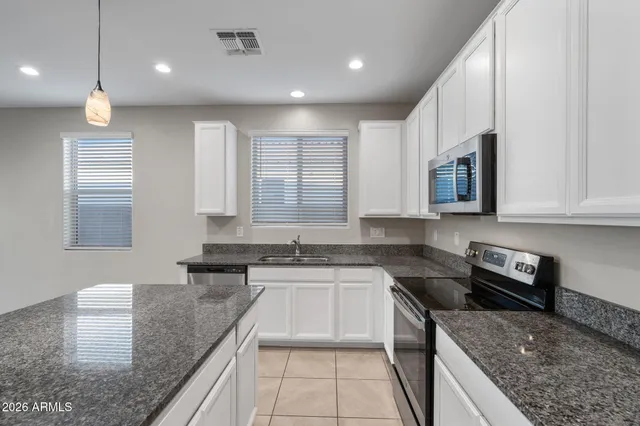 a kitchen with stainless steel appliances granite countertop a sink stove and cabinets