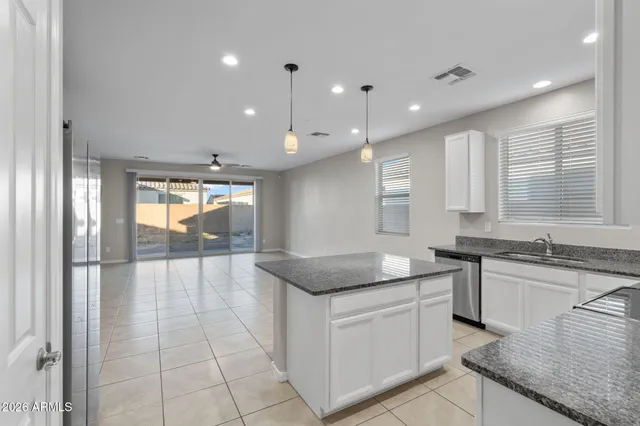 a kitchen with a granite countertop sink and cabinets