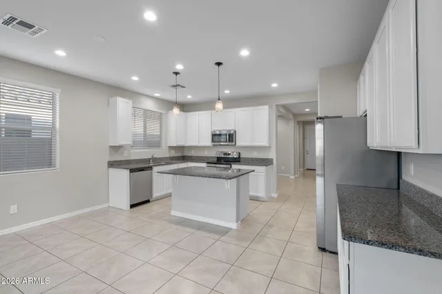 a kitchen with stainless steel appliances granite countertop a sink and a refrigerator