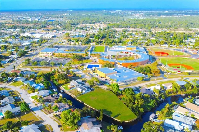 an aerial view of residential houses with outdoor space and trees