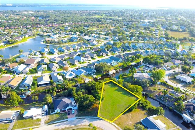 an aerial view of a residential houses with outdoor space and trees