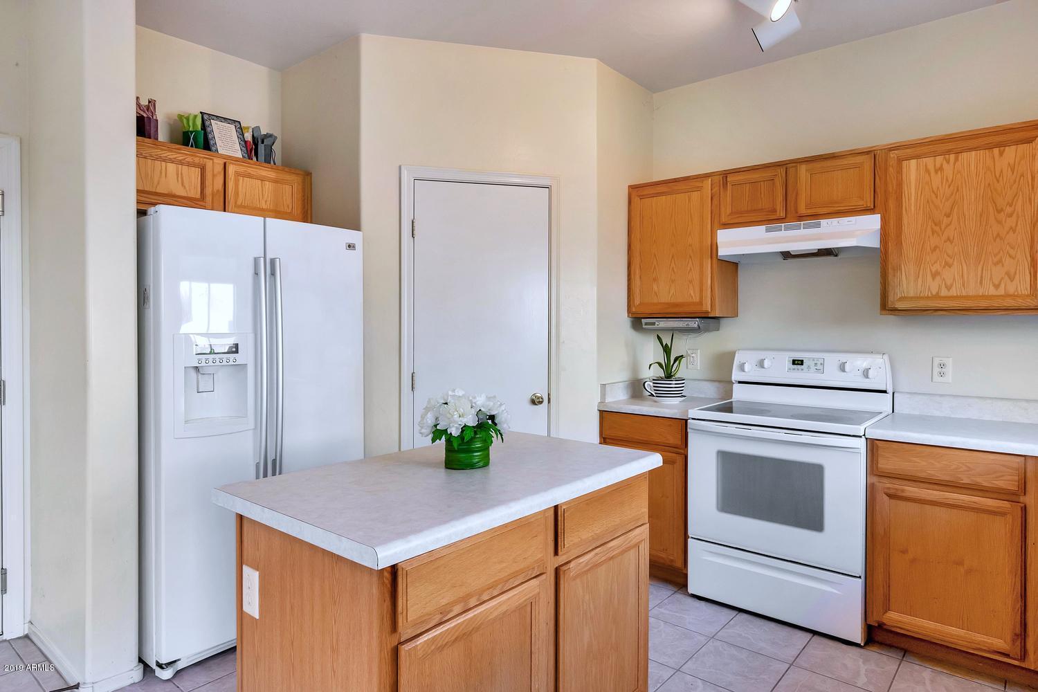4138 West Carter Road Phoenix, AZ 85041 - Photo 13 of 31 a kitchen with stainless steel appliances a stove a sink and a refrigerator