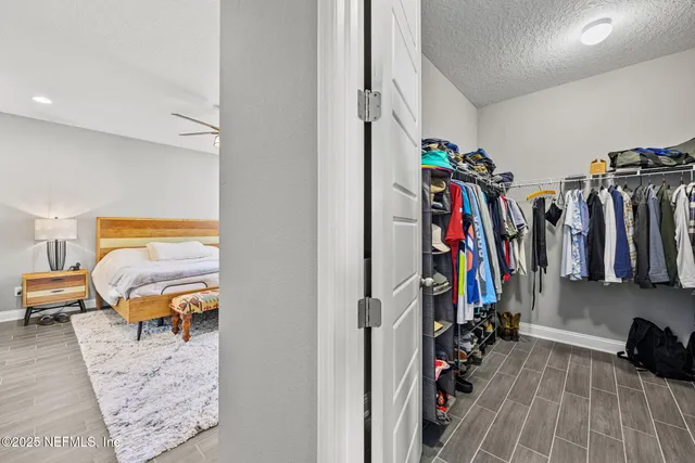 a view of walk in closet with clothes and shoes