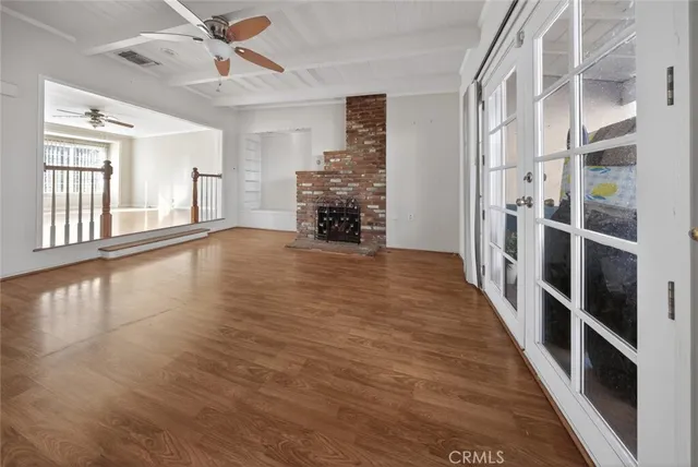 a view of a livingroom with wooden floor and a ceiling fan