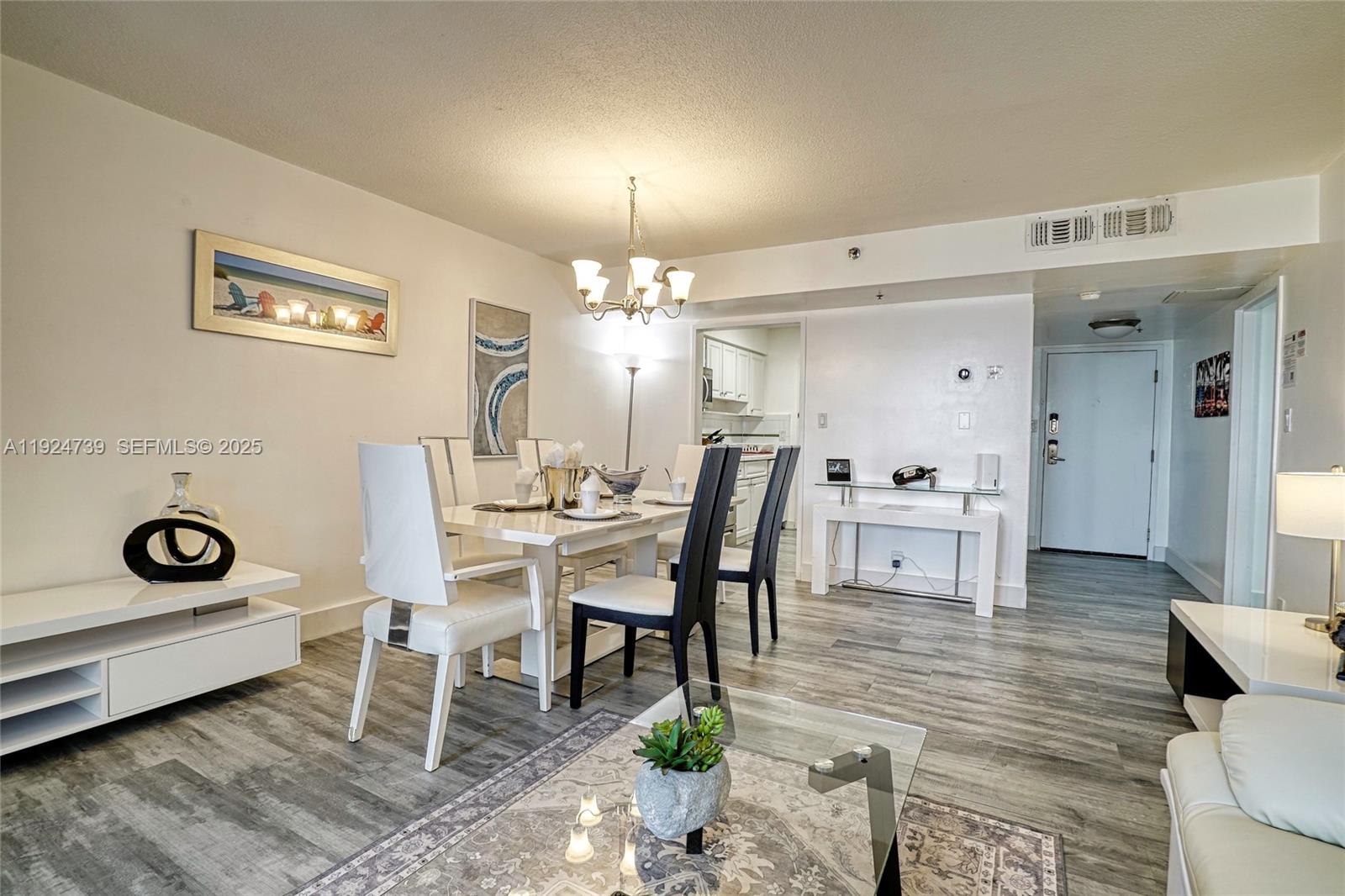 5225 Collins Avenue, Unit 1204 Miami Beach, FL 33140 - Photo 29 of 49 a view of a dining room with furniture and chandelier