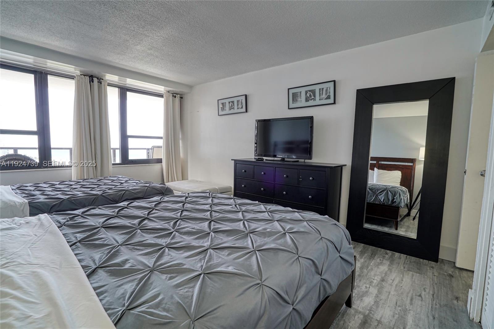 5225 Collins Avenue, Unit 1204 Miami Beach, FL 33140 - Photo 35 of 49 a bedroom with a large bed and a tv