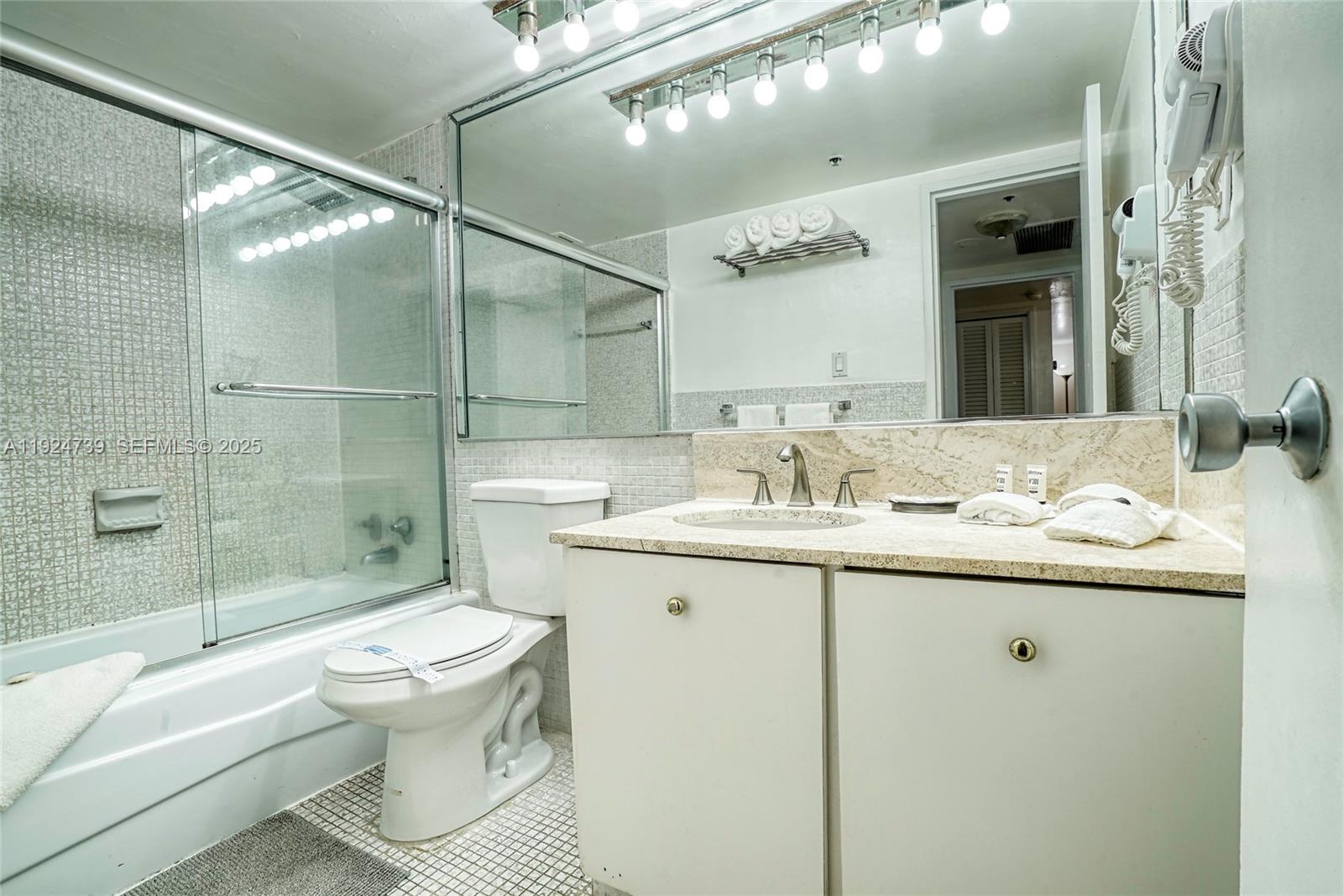 5225 Collins Avenue, Unit 1204 Miami Beach, FL 33140 - Photo 36 of 49 a bathroom with a sink toilet and shower