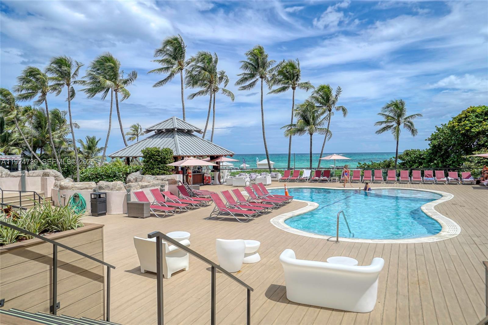 5225 Collins Avenue, Unit 1204 Miami Beach, FL 33140 - Photo 8 of 49 a view of a swimming pool with a table and chairs