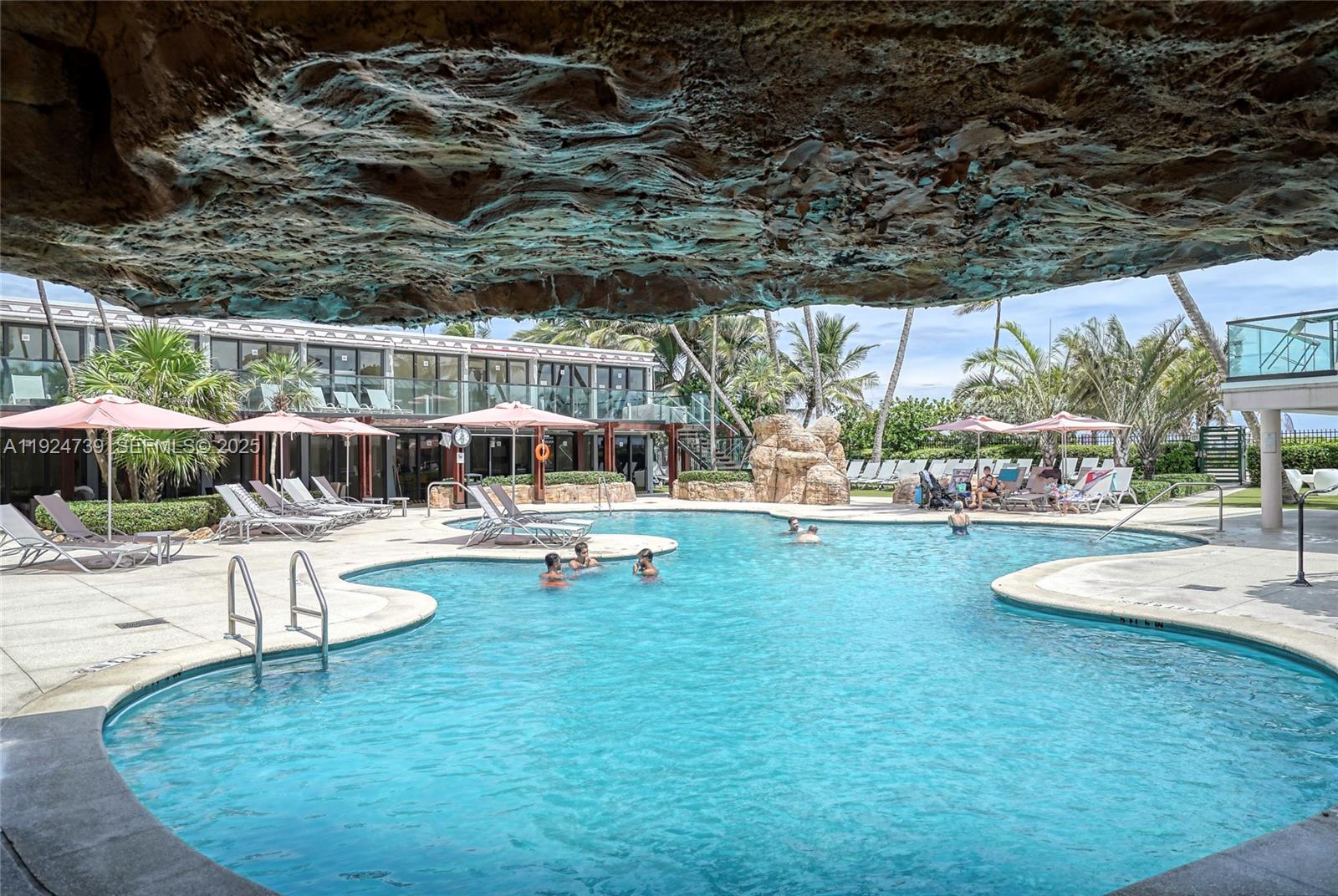 5225 Collins Avenue, Unit 1204 Miami Beach, FL 33140 - Photo 9 of 49 a view of a swimming pool with lawn chairs and couches