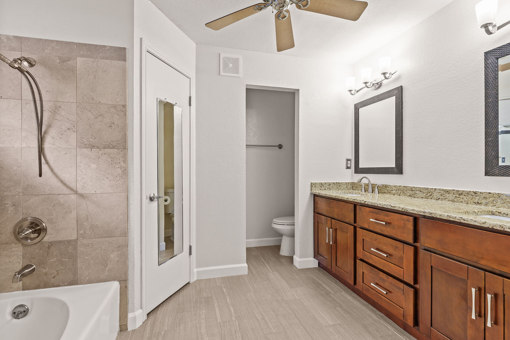 2409 Water Well Lane Austin, TX 78728 - Photo 14 of 22 Bathroom featuring a double vanity with wood-finish cabinetry, light-colored countertops, and brushed nickel hardware