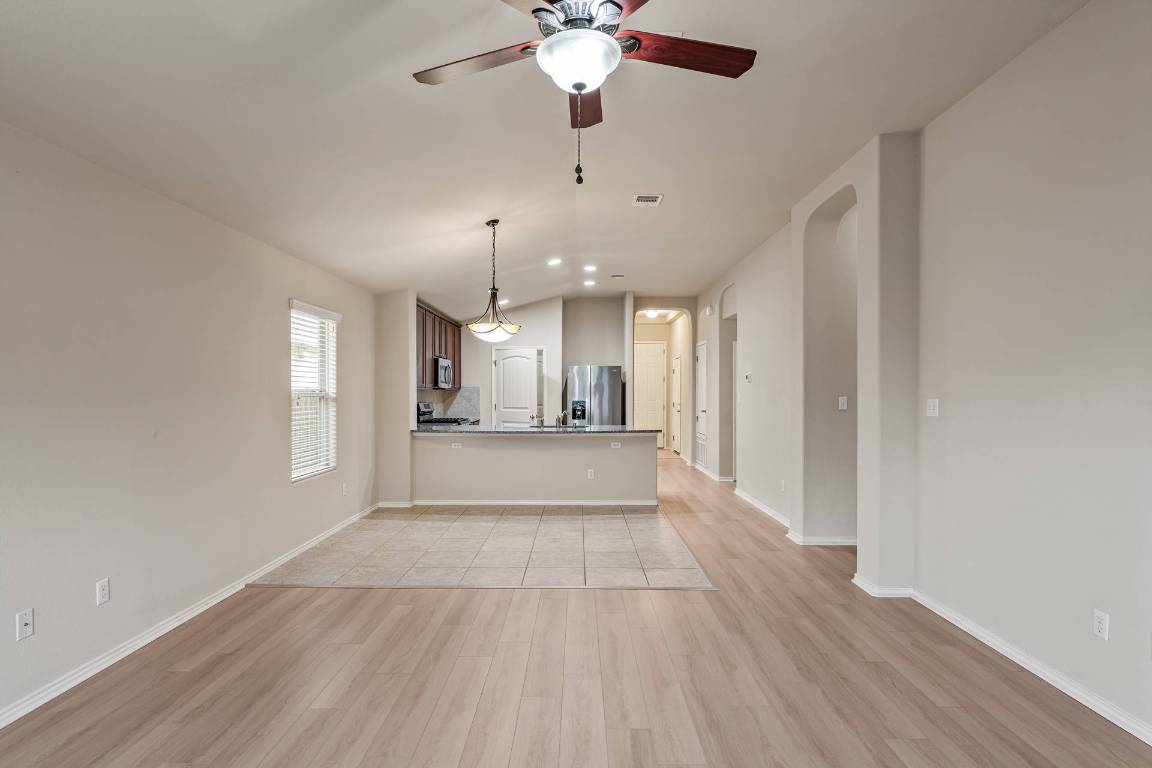 180 Fletcher Bend Buda, TX 78610 - Photo 14 of 36 a view of an empty room with wooden floor and a window