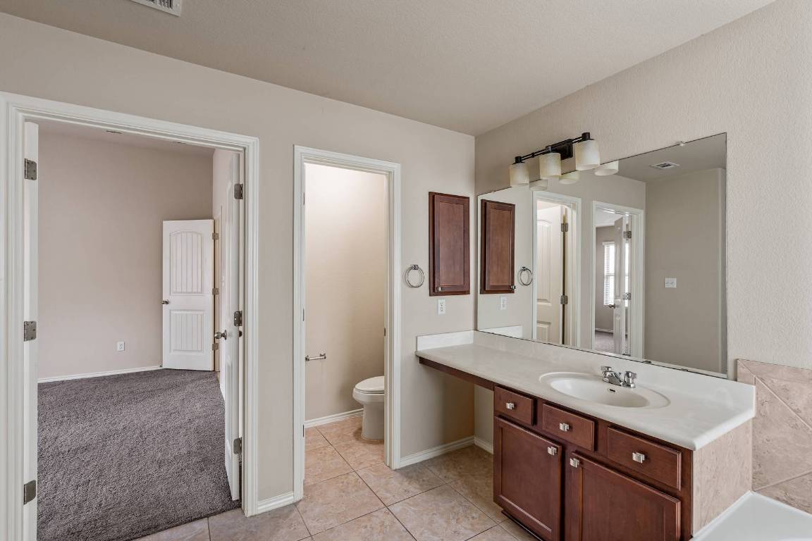 180 Fletcher Bend Buda, TX 78610 - Photo 17 of 36 a bathroom with a sink double vanity and a shower