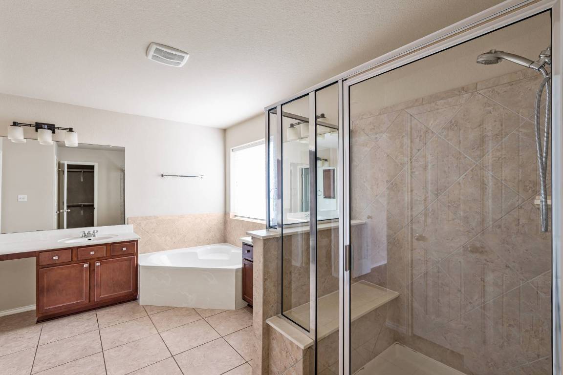 180 Fletcher Bend Buda, TX 78610 - Photo 18 of 36 a bathroom with a tub shower vanity and sink