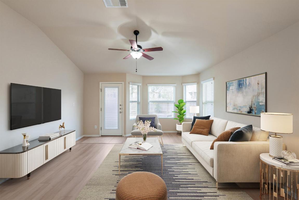 180 Fletcher Bend Buda, TX 78610 - Photo 2 of 36 Gorgeous living room showcases plank flooring, ceiling fan, bay window, and a backdoor leading to your deck and private fenced backyard. Virtually Staged.