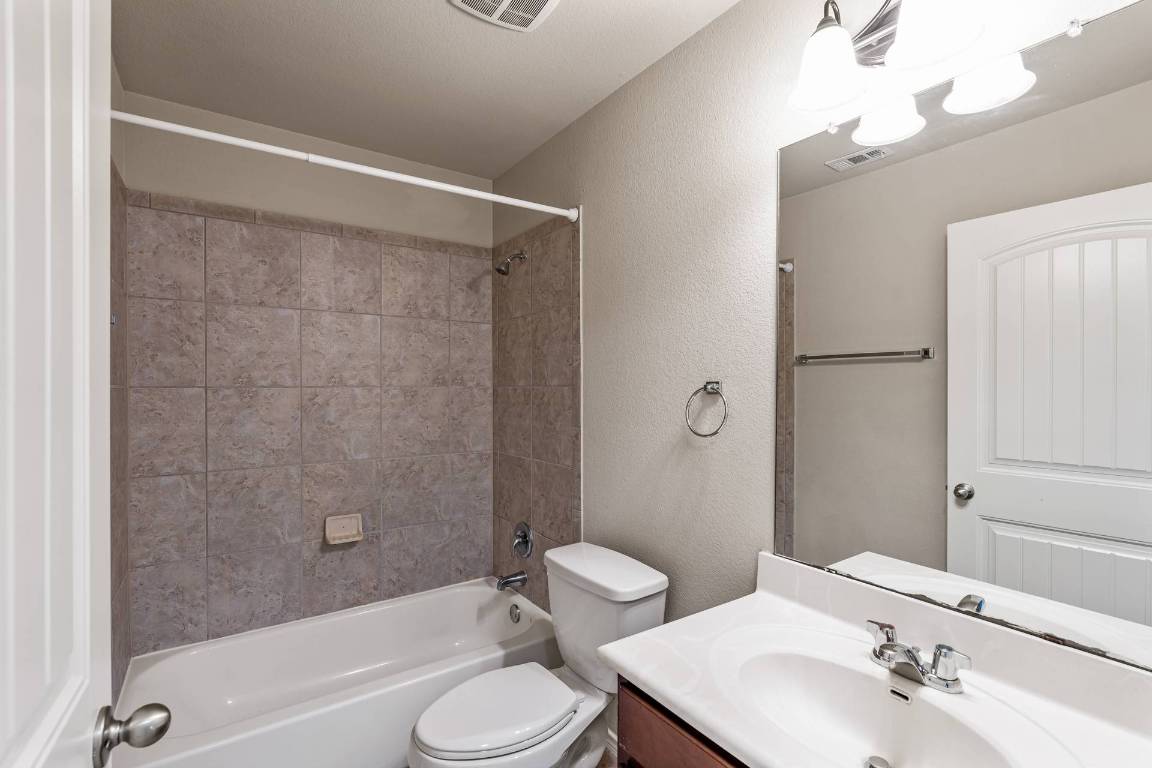 180 Fletcher Bend Buda, TX 78610 - Photo 23 of 36 a bathroom with a toilet a sink and a bathtub