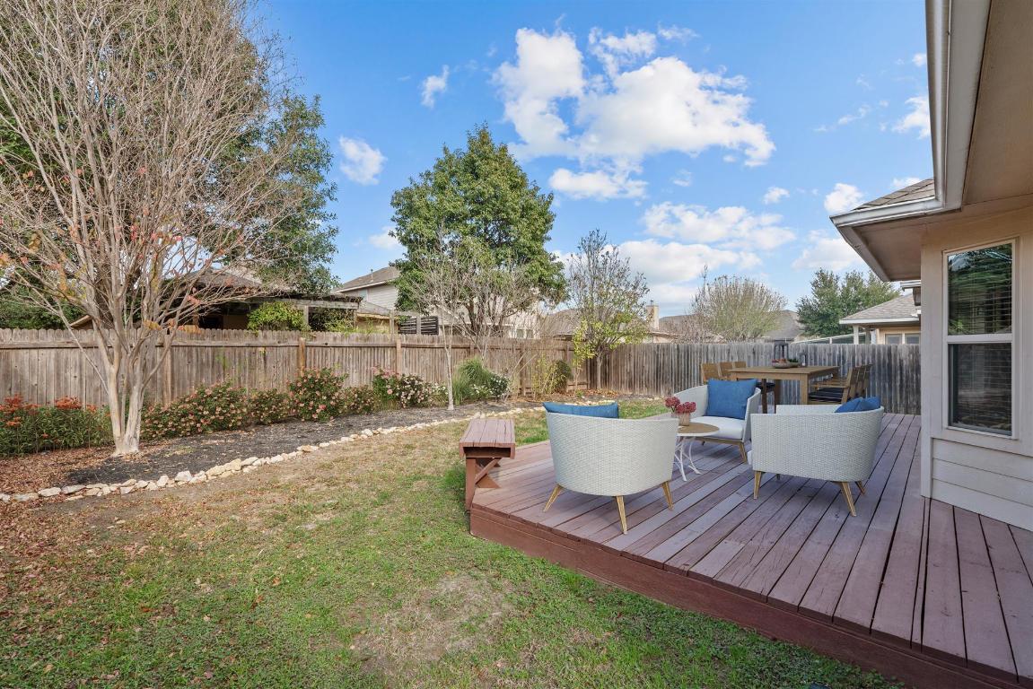 180 Fletcher Bend Buda, TX 78610 - Photo 5 of 36 Back of house featuring a fenced backyard and a spacious wooden deck for entertaining. Perfect for kids and your four-legged family member. Virtually Staged.