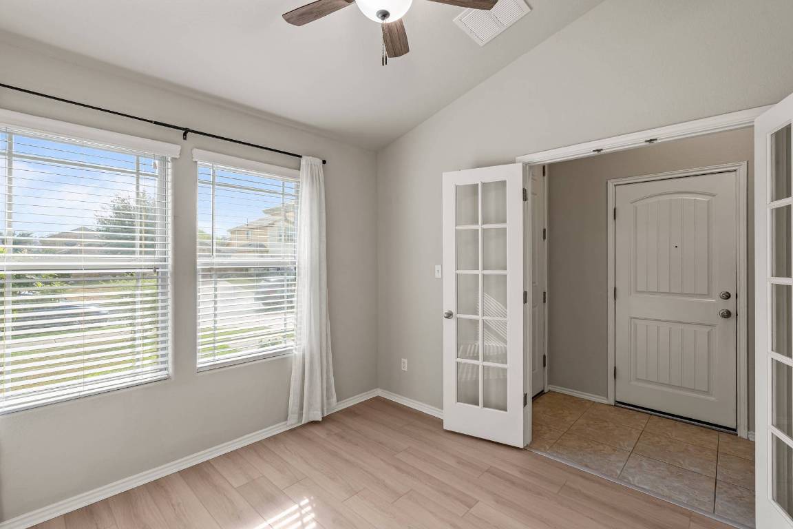 180 Fletcher Bend Buda, TX 78610 - Photo 7 of 36 a view of an empty room with a window and wooden floor