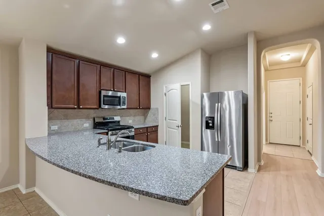 a kitchen with stainless steel appliances granite countertop a sink and stove top oven