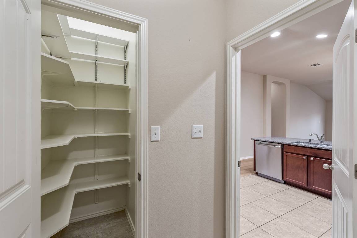 180 Fletcher Bend Buda, TX 78610 - Photo 10 of 36 a view of a hallway to room with cabinet and mirrors