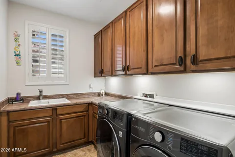 a kitchen with white cabinets and sink