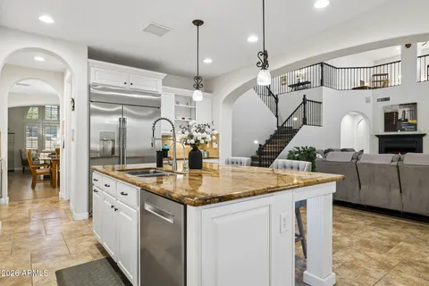 a living room with stainless steel appliances granite countertop furniture and a large window