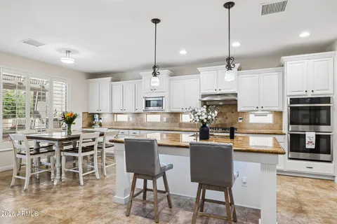 a kitchen with kitchen island granite countertop a sink a counter and living room view