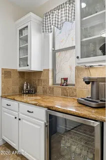 a kitchen with stainless steel appliances granite countertop a table chairs stove and white cabinets