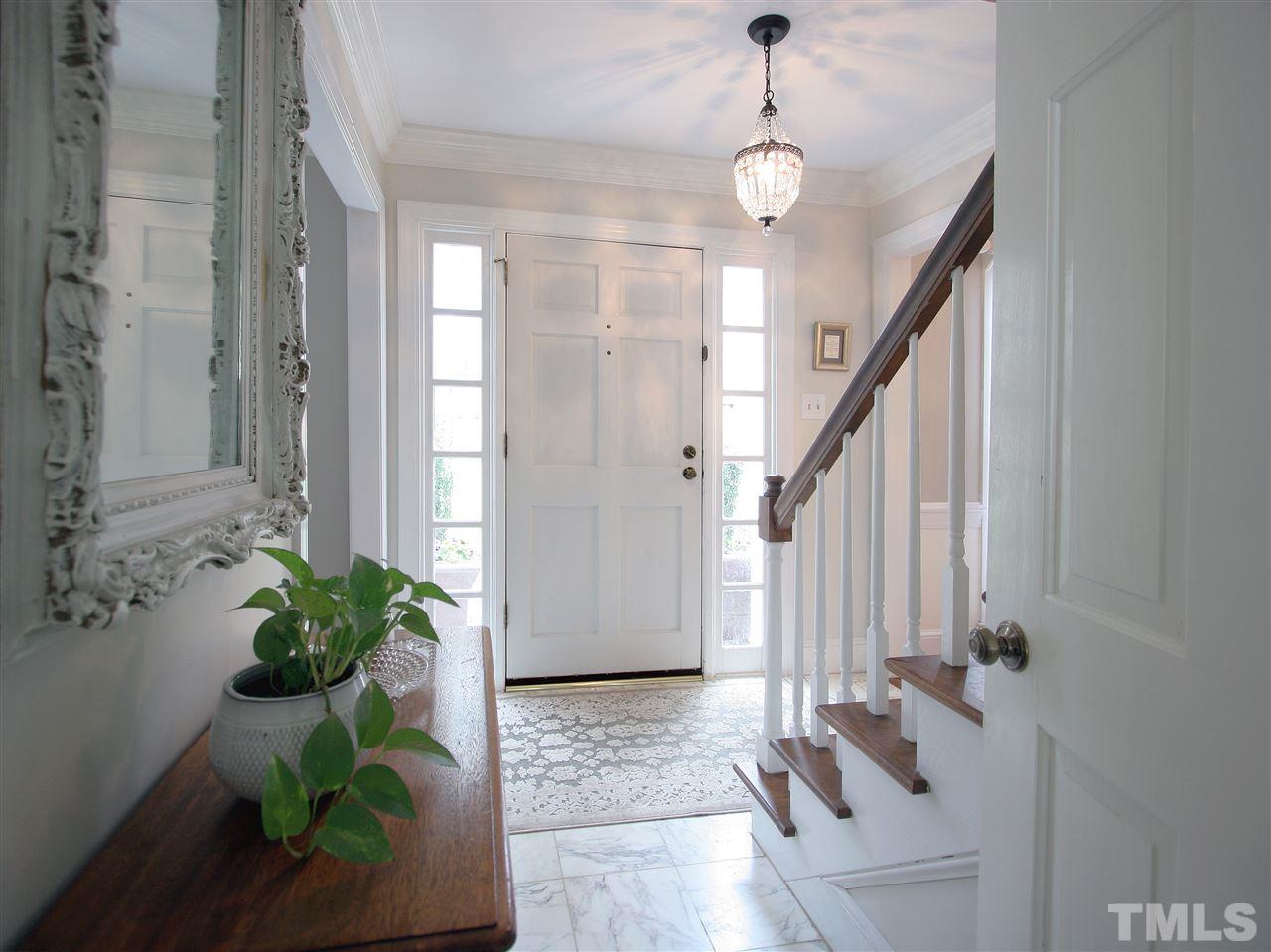 The foyer is light and bright. Elegant marble-tile flooring. Lovely lighting fixture. The formal living room/office and the dining room flank the foyer.
