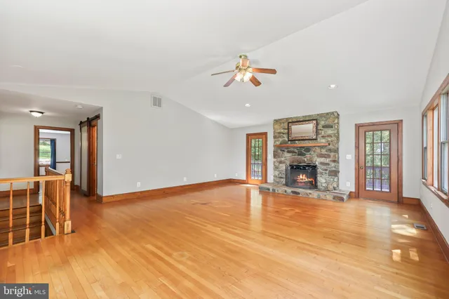 a spacious bedroom with a large bed a flat tv screen and a dresser