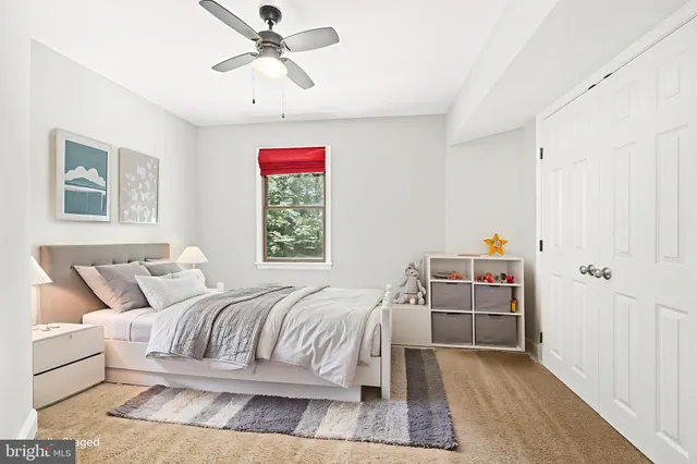 an empty room with a window and a ceiling fan