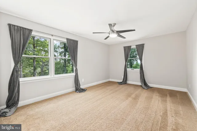 an empty room with closet and a ceiling fan