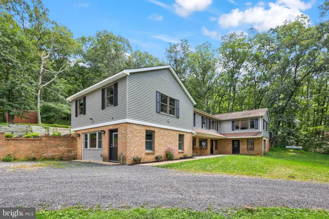 a view of a yard in front of a house with large windows