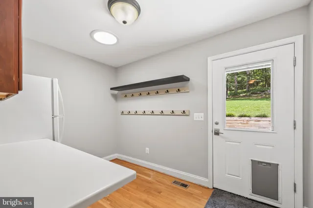 an empty room with windows fireplace and wooden floor