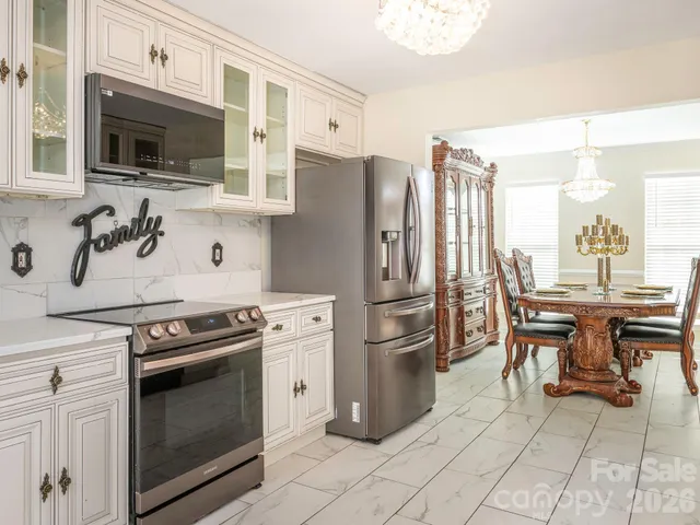 a kitchen with stainless steel appliances granite countertop a stove a sink dishwasher and a refrigerator