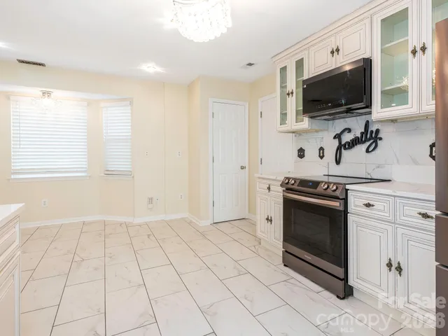 a view of kitchen with stainless steel appliances and cabinets
