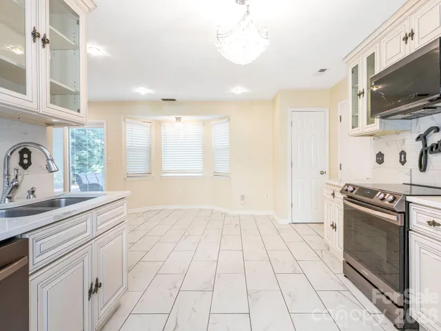 a kitchen with stainless steel appliances granite countertop a sink and a stove