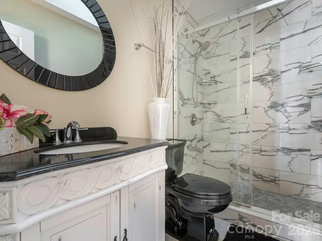 a bathroom with a granite countertop toilet sink and mirror