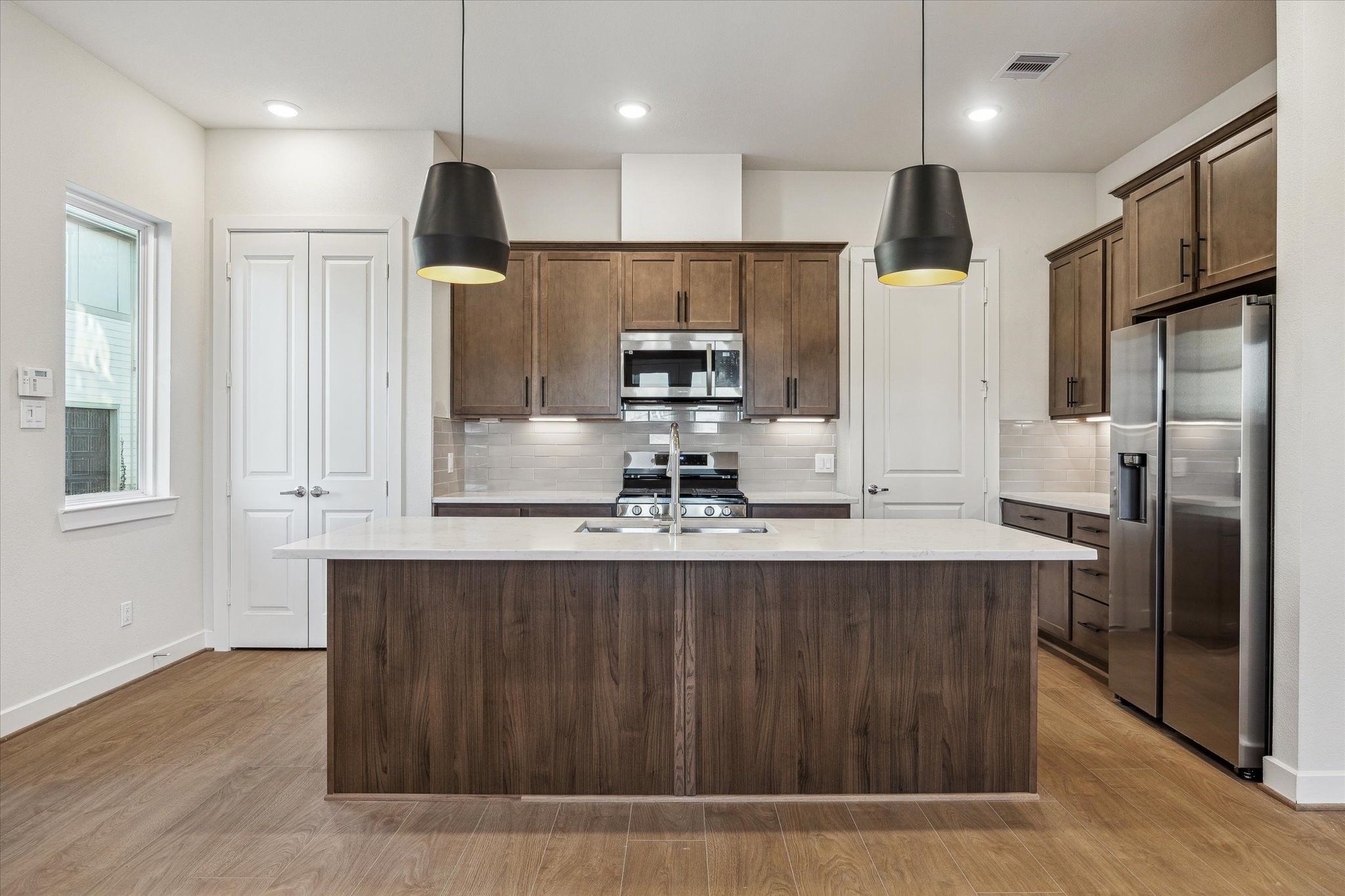 6517 Rena Street Houston, TX 77092 - Photo 4 of 11 a kitchen with kitchen island stainless steel appliances a sink and a refrigerator