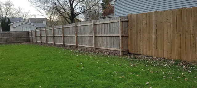 a view of backyard with wooden fence