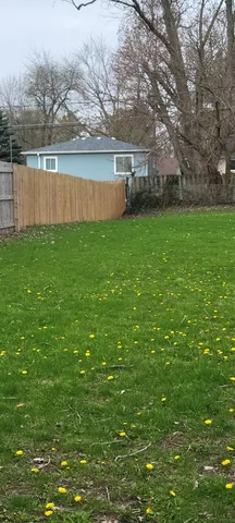 a view of yard with green space and lake view in back
