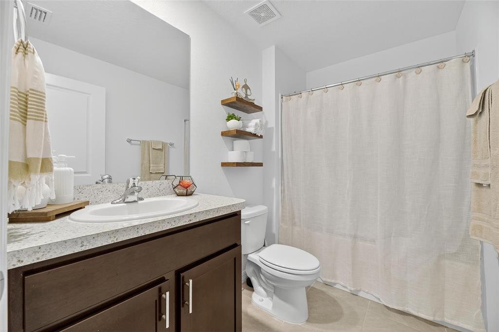 3602 Forest Path Drive Plant City, FL 33565 - Photo 14 of 75 a bathroom with a sink a toilet and shower curtain