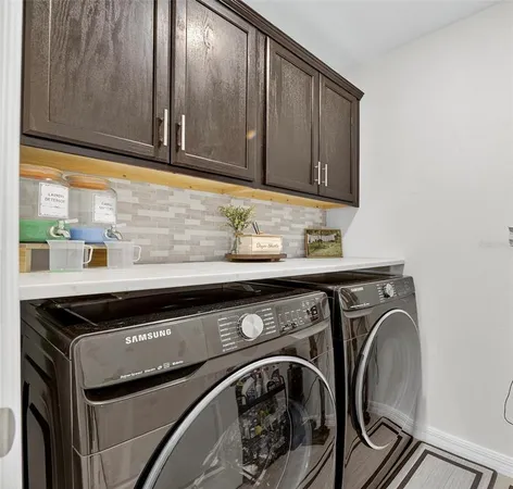 a kitchen with stainless steel appliances a stove a sink a microwave a refrigerator and chairs