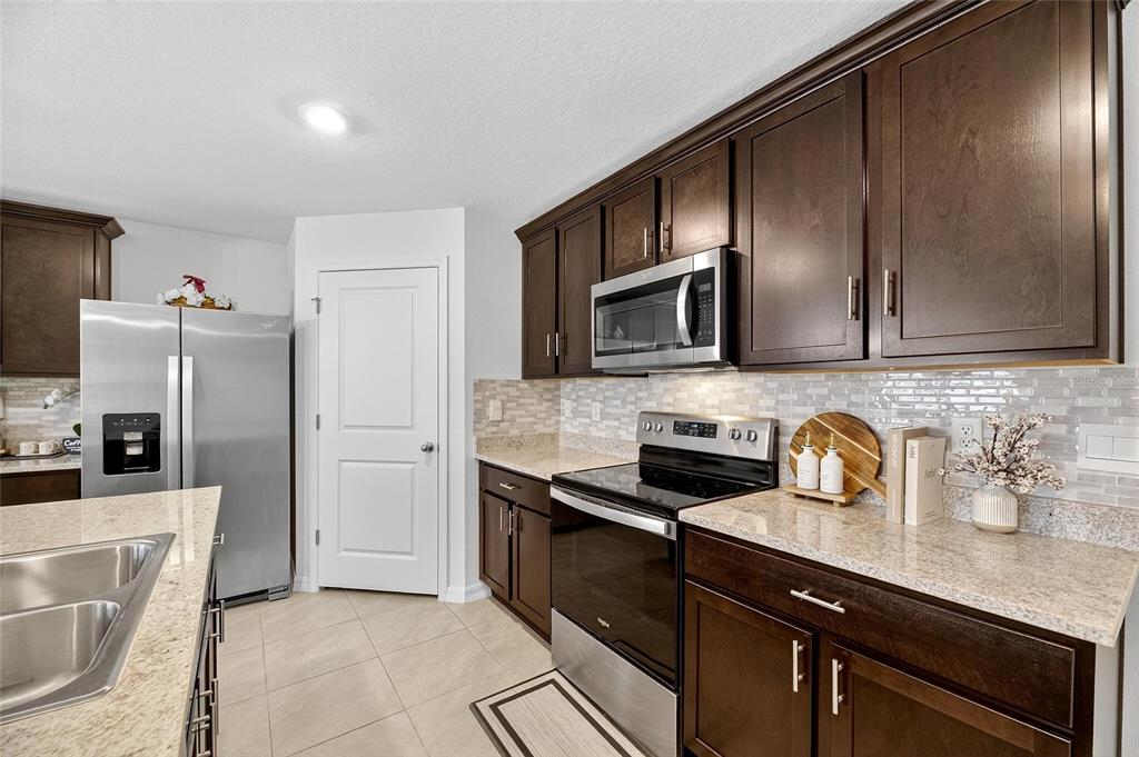 3602 Forest Path Drive Plant City, FL 33565 - Photo 26 of 75 a kitchen with stainless steel appliances granite countertop a sink stove and refrigerator
