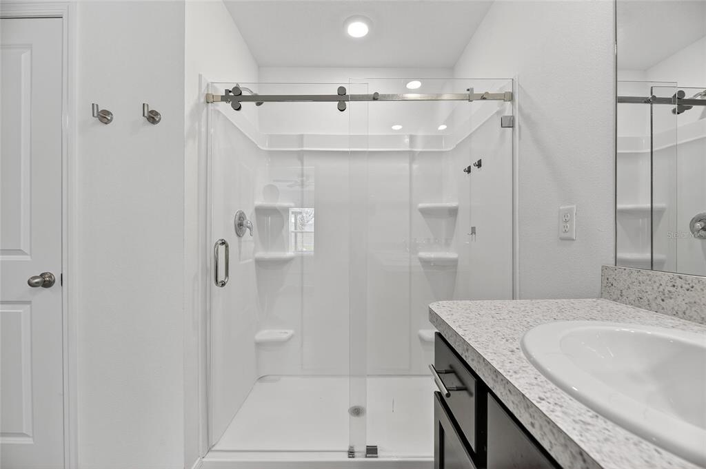 3602 Forest Path Drive Plant City, FL 33565 - Photo 39 of 75 a bathroom with a granite countertop sink a shower and mirror