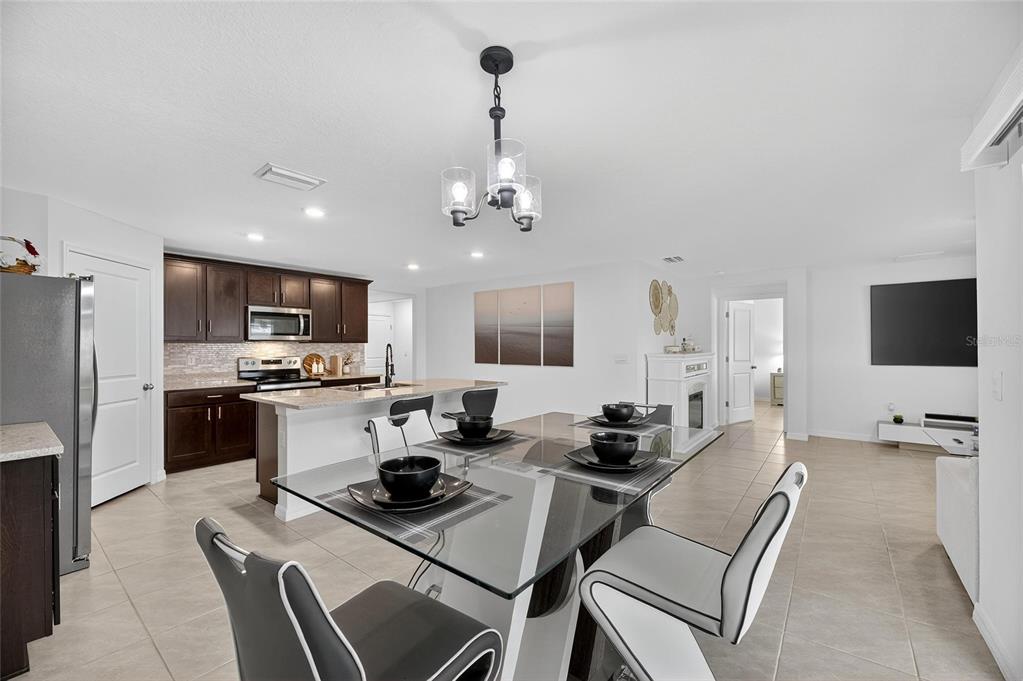 3602 Forest Path Drive Plant City, FL 33565 - Photo 45 of 75 a kitchen with stainless steel appliances kitchen island granite countertop a sink dishwasher a stove and a refrigerator with wooden floor