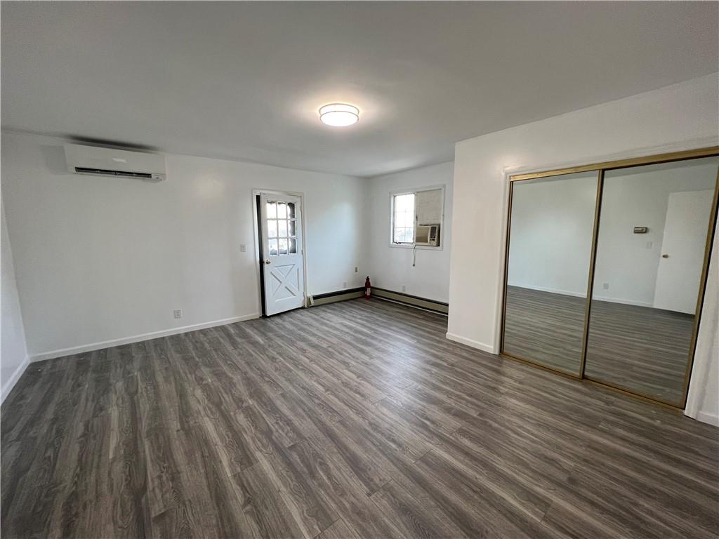 212 Manor Road Staten Island, NY 10314 - Photo 11 of 12 an empty room with wooden floor and sliding door