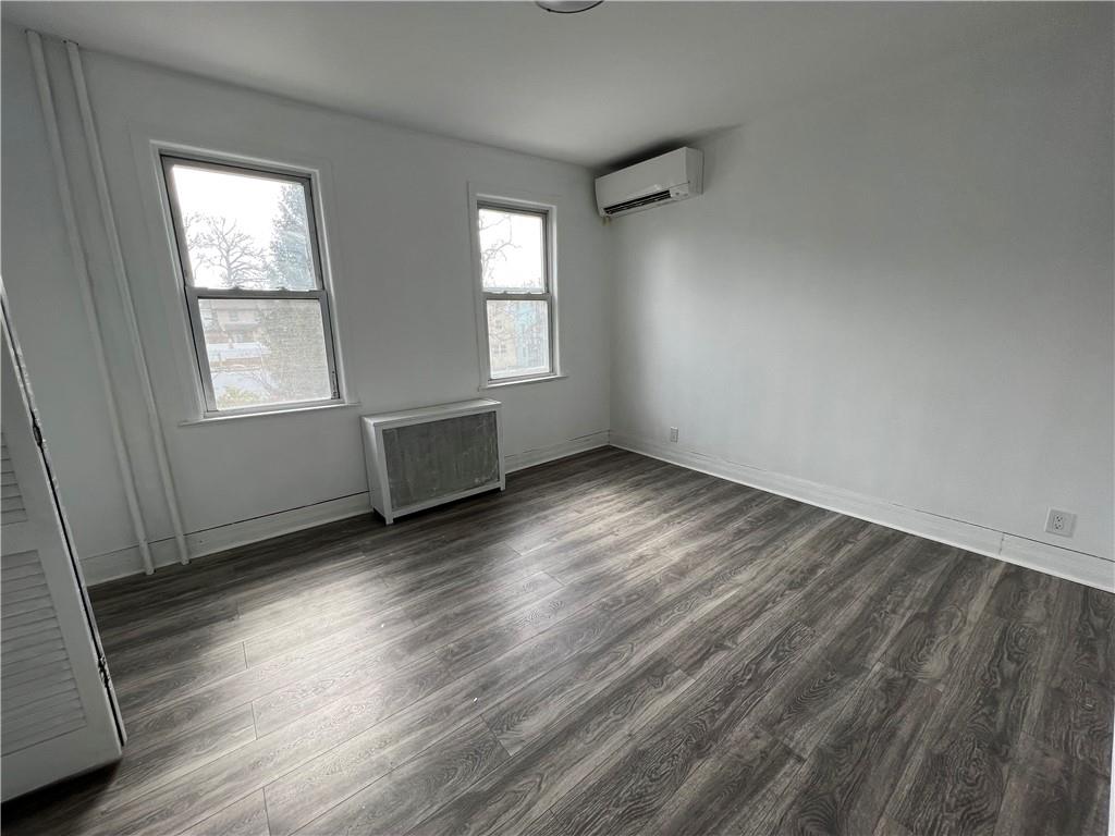 212 Manor Road Staten Island, NY 10314 - Photo 12 of 12 an empty room with wooden floor and windows