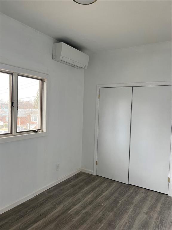 212 Manor Road Staten Island, NY 10314 - Photo 5 of 12 a view of an empty room with wooden floor and a window